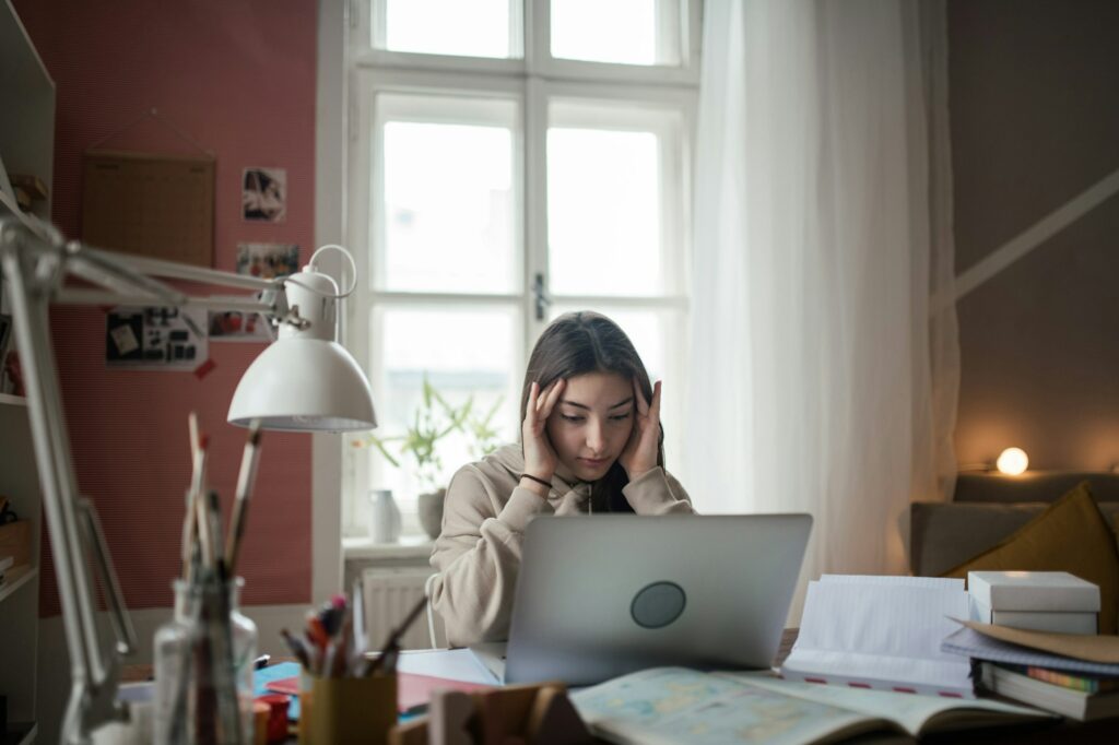 Young teenage girl studying in her room.